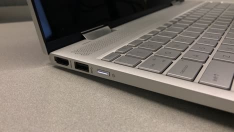 Finger-pushing-on-power-button-of-laptop-computer
