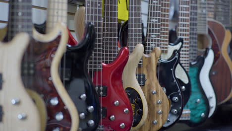 Assortment-of-Hanging-Guitars-for-Sale-in-Shop,-Pan-Across,-Wide