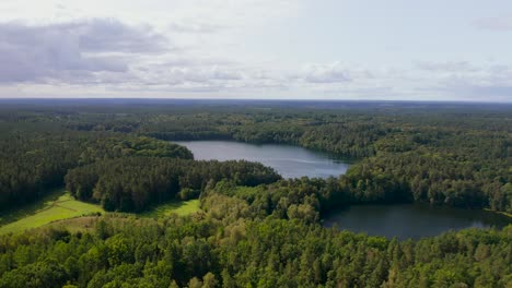 Aerial-rising-view-overlooking-vast-back-country-woodland-wilderness-and-lake