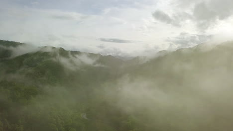 Vista-Aérea-Volando-A-Través-De-La-Mañana-Lluvia-Cubierta-De-Nubes-Selva-Tropical-Paisaje-Montañoso-Durante-La-Temporada-De-Lluvias-En-El-Parque-Nacional-Reservado-De-La-Montaña-Doi-Phuka-El-Norte-De-Tailandia