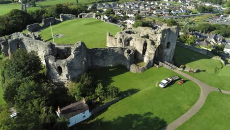 Medieval-Welsh-landmark-Denbigh-Castle-medieval-old-hill-monument-ruin-tourist-attraction-aerial-view-rising-top-down