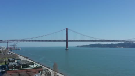 Aerial-Drone-Shot-over-the-Tagus-River-with-the-25th-of-April-Bridge-in-the-background-in-Lisbon,-Portugal