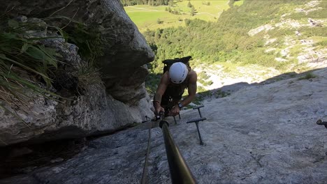 Active-and-extreme-tourism-experience-filmed-by-a-young-and-fit-man,-climbing-up-between-two-cliffs-high-up-on-a-mountain-side