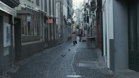 Still-shot-Funchal-old-town-street-with-woman-walking-away,-Madeira-Island