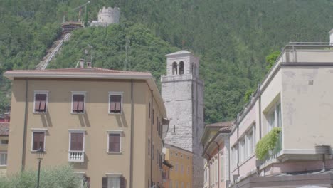Long-distance-shot-of-an-old-belfry-in-the-center-of-Riva-Del-Garda-in-North-Italy-with-mountains-in-the-background