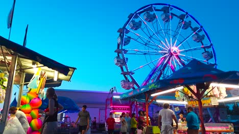 Brightly-lit-carnival-ferris-wheel-in-a-summer-evening