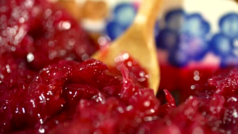 Close-up-shot-of-juicy-crushed-cherries,-taking-a-spoonful-of-cherries