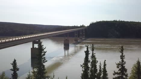 Yukon-River-Bridge-Crossing-in-Alaska-Wilderness-Landscape---Aerial-Drone-Approaching-View