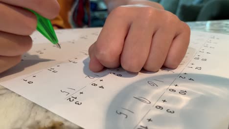 Elementary-aged-student-doing-math-on-a-practice-worksheet