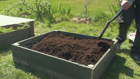 Leveling-compost-with-shovel-in-raised-garden-bed
