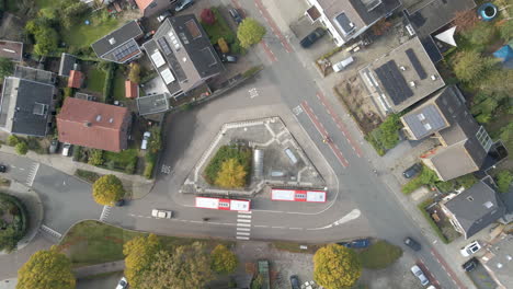 Top-down-aerial-of-people-stepping-out-of-bus-at-bus-station---drone-setting-down