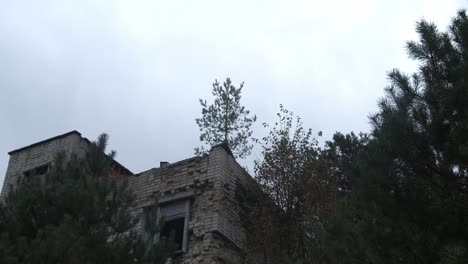 Espeluznante-Casa-Abandonada-Con-árboles-En-Primer-Plano-En-La-Zona-De-La-Planta-De-Energía-Nuclear-De-Chernobyl-En-Pripyat,-Ucrania