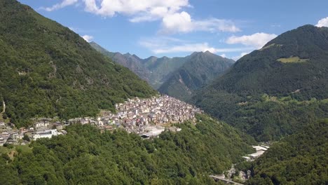 Aerial-of-a-beautiful-small-village-on-a-lush-green-mountain,-Premana,-Italia
