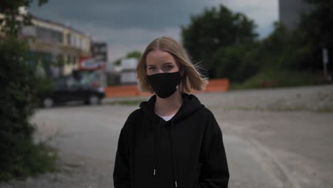 Portrait-of-a-Young-Blonde-Female-With-Face-Mask-in-Exterior-Looking-at-Camera