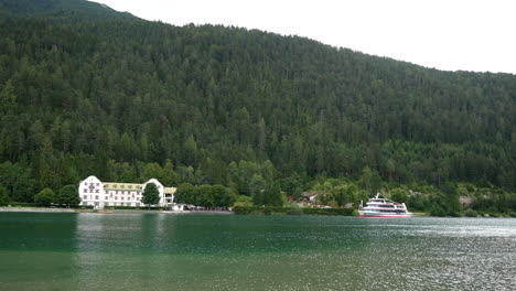 Hermoso-Paisaje-De-Montaña-Con-Bosque,-Hotel-Y-Barco-Turístico-De-Estacionamiento-En-El-Lago-Achen,-Austria
