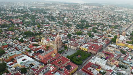 Drone-Circles-Above-San-Miguel-De-Allende-City-Plaza,-Parroquia-De-San-Miguel-Arcángel