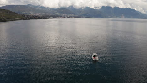 Aerial-view-of-small-boat-on-a-beautiful-lake-with-mountains-in-the-distance
