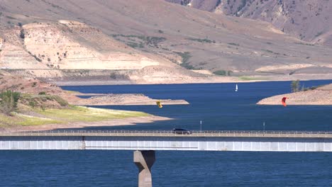 Cars-passing-a-bridge-over-a-reservoir-in-Gunnison,-Colorado