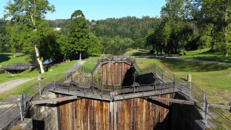 Aerial-rising-out-of-old-lock-chamber-with-large-wooden-gate-in-front