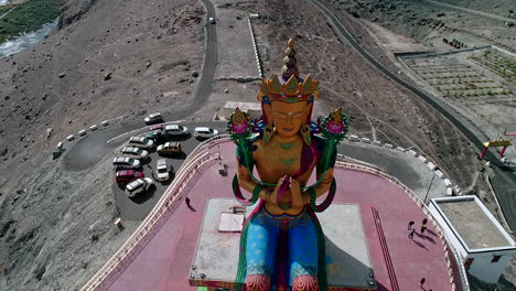 bird-eye-view-of-a-tall-budha-sculpture-in-a-mountain-valley-with-visitors