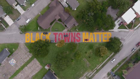 Bird-eye-view-of-a-large-"Black-Towns-Matter"-sign-painted-on-street-in-Houston-Historical-independence-Heights-district
