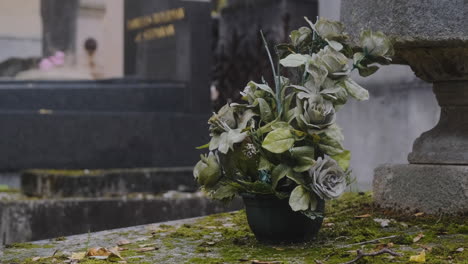 Beautiful-roses-in-a-flower-pot-on-top-of-a-grave-a-rainy-day-in-pere-lachaise-cemetary