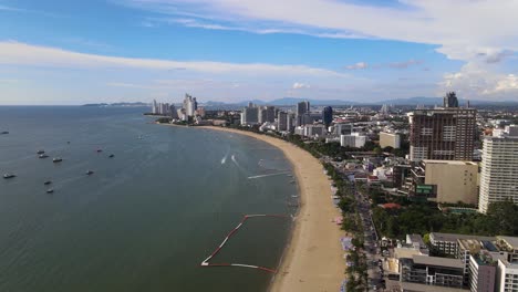 Vista-Aérea-De-La-Playa-Y-El-Paisaje-Urbano-De-Pattaya,-Movimiento-Deslizante-Y-Giratorio