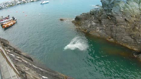 Young-man-jumping-into-water-of-coast-of-Manarola