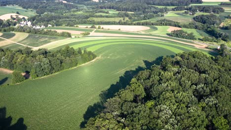 aerial-flight-over-farms-tilts-down-to-beautiful-curved-patterns-in-the-crops