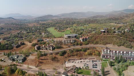 Aerial-wide-view-of-housing-and-a-golf-course,-in-Steamboat-Springs,-Colorado-on-a-hazy-day-in-the-early-fall