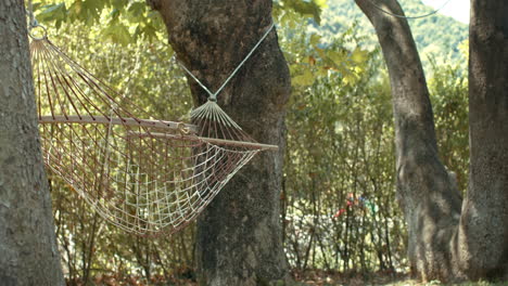 Calm-and-Peaceful-Hammock-Swinging-with-Gentle-Breezing-Wind,-Hung-between-Trees-in-slowmo