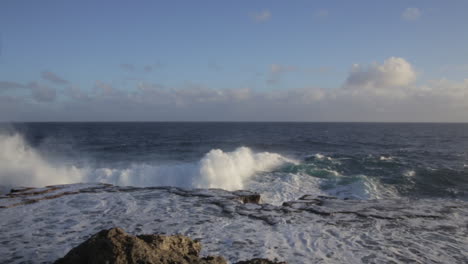 Static-Shot-of-Violent-Waves-Crashing-into-the-Rocky-Shoreline-During-the-evening