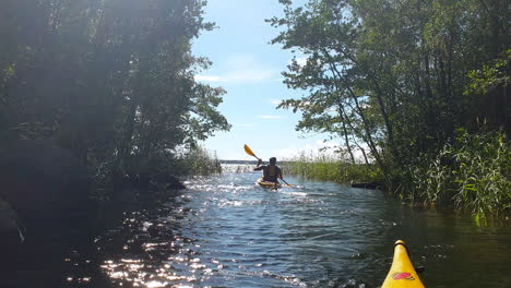Guy-Kayaking-in-Narrow-River,-Summer-Adventure,-POV-from-Kayak