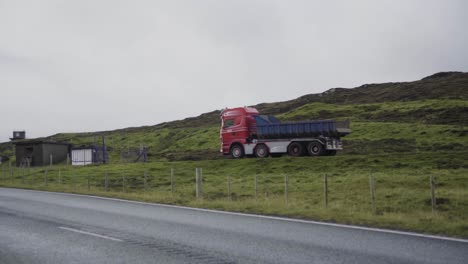 Panning-shot-of-driving-truck-on-rural-faeroese-road-during-cloudy-day-on-Faeroe-Island