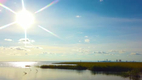 4K-pan-left-to-right-from-sun-in-left-center-frame-to-Atlantic-City-skyline-in-distance-in-center-frame-on-a-nice-mostly-sunny-day