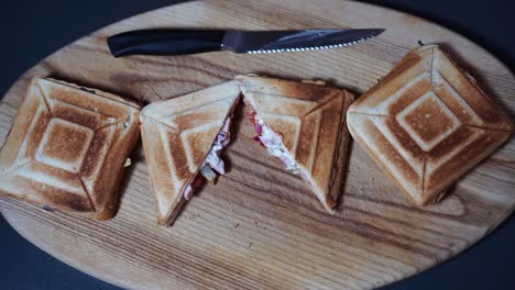 Beautifully-placed-delicious-sandwiches-on-wooden-board-while-putting-knife-a-side