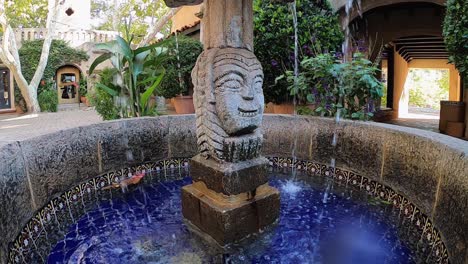 Slow-motion-of-water-splashed-on-the-lens-of-the-camera,-from-a-fountain-made-of-decorative-carved-stone-at-the-Tlaquepaque-Arts-and-Shopping-Village,-Sedona,-Arizona
