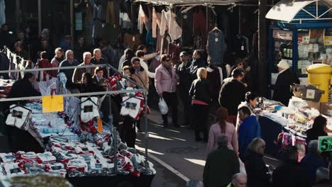 Crowds-of-people-shop-and-browse-at-an-outdoor-market-on-a-cold-day-static-tripod-shot