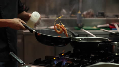 Chef-Doing-Flambe-In-The-Kitchen-Of-A-Restaurant---Chef-Tossing-And-Pouring-White-Wine-On-The-Shrimp-Cooked-On-A-Frying-Pan