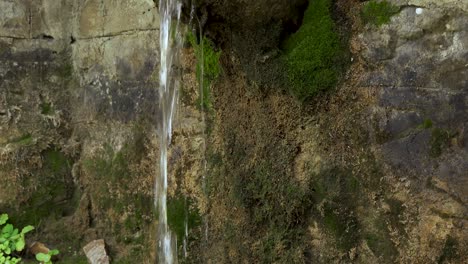Water-fountain-falling-from-carved-old-stone-covered-in-moss-on-mountain-village-of-Dardha-in-Albania