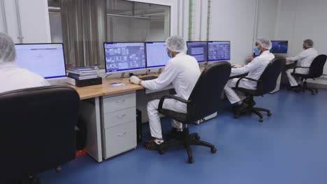 Zoom-in-shot-of-people-with-ppe-working-on-computers-in-a-factory