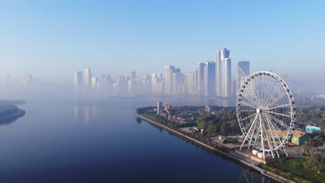 View-from-above-of-Sharjah's-Khalid-Lake,-Eye-of-Emirates,-Sharjah-Skyline-on-a-foggy-morning,-United-Arab-Emirates,-4K-video
