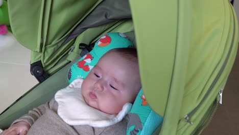 Adorable-baby-girl-lying-in-stroller-when-Mom-shaking-it-to-calm-her-down
