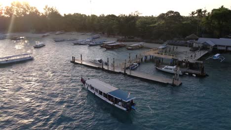 Touristisches-Ausflugsboot,-Das-Den-Pier-Auf-Der-Insel-Gili-Air-Während-Des-Sonnenuntergangs-Im-Hintergrund-Ankommt