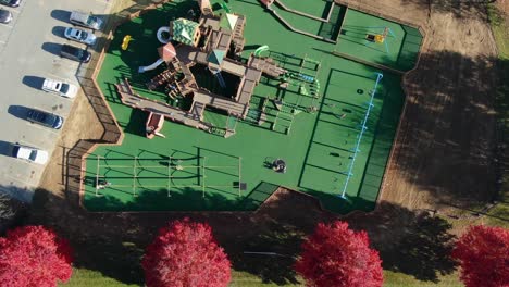 Top-down-birdseye-aerial-of-children-on-playground-equipment-at-park-during-sunny-autumn-day