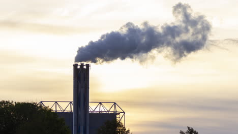 Time-lapse-of-smoking-factory-chimney-against-the-background-of-a-setting-sun---crop