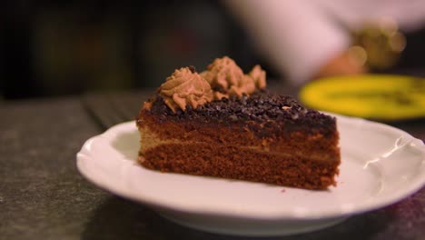 Unglaublicher-Schuss-Schokoladenkuchen,-Serviert-Von-Einer-Kellnerin,-Die-Auf-Einem-Weißen-Teller-Im-Restaurant-Bereitsteht