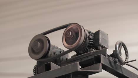 Rotating-Metal-Gear-With-Engine-Belt-In-A-Factory---close-up,-slider-right