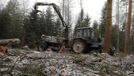 Máquina-Forestal-Cargando-Troncos-En-El-Bosque-Durante-La-Tormenta-De-Nieve---Plano-General