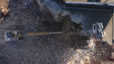 Aerial-drone-view-of-Heavy-Machinery-working-on-the-process-of-demolishing-a-concrete-building